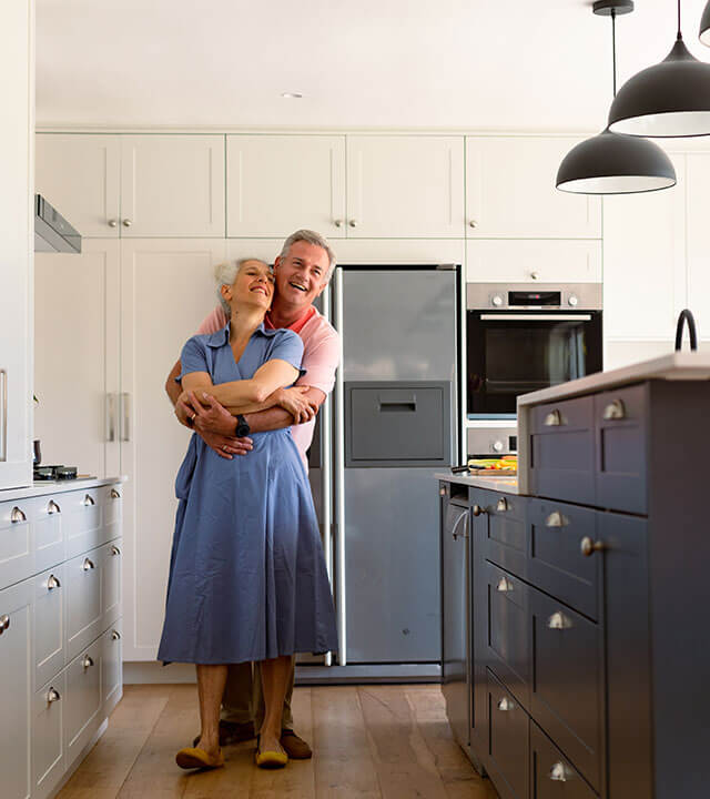 cabinet-painting-happy-caucasian-senior-couple-dancing-together-in-kitchen-01 older couple dancing in newly painted kitchen